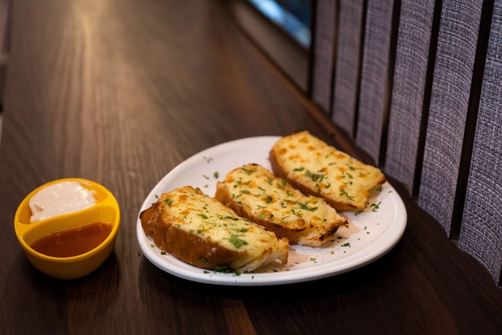 Close-up of delicious garlic bread with dip on a wooden table.